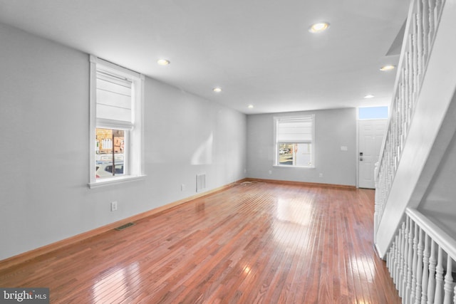 unfurnished room featuring hardwood / wood-style floors, stairway, visible vents, and recessed lighting