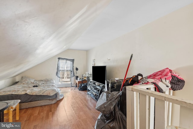 bedroom with lofted ceiling and wood finished floors