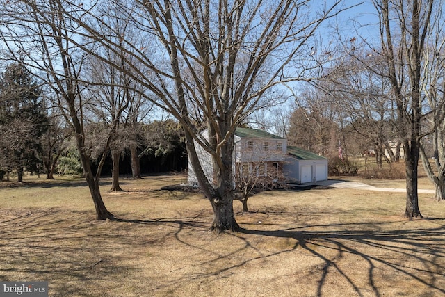 view of side of home with driveway and an attached garage