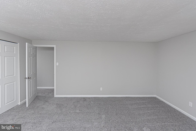 interior space featuring carpet floors, baseboards, and a textured ceiling