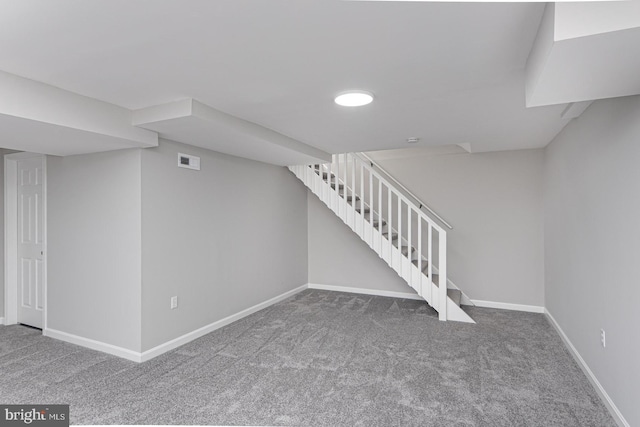 finished basement featuring carpet floors, visible vents, stairway, and baseboards