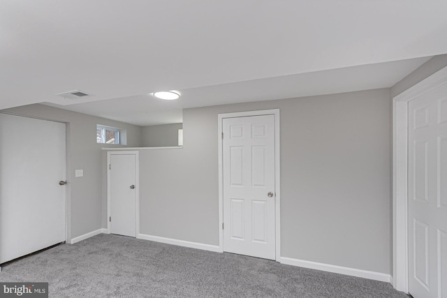 basement with carpet flooring, visible vents, and baseboards