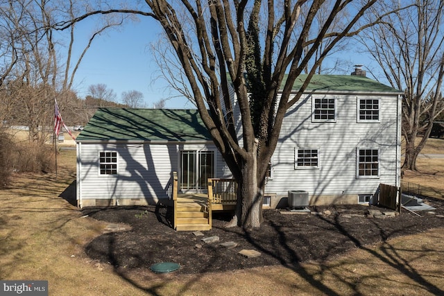 back of house with a chimney, a deck, and cooling unit