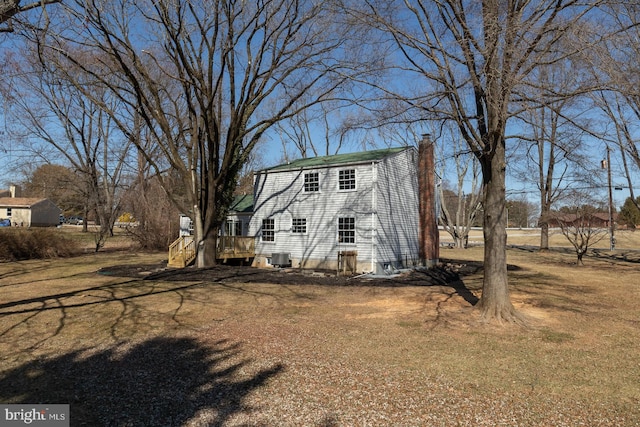 exterior space with a chimney and central AC unit