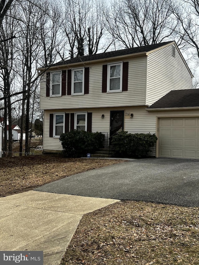 colonial-style house featuring a garage and driveway