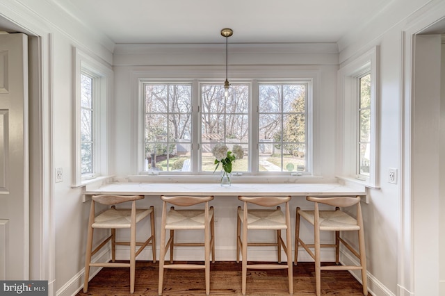 dining space featuring breakfast area, plenty of natural light, and wood finished floors