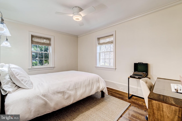 bedroom featuring baseboards, wood finished floors, a ceiling fan, and crown molding