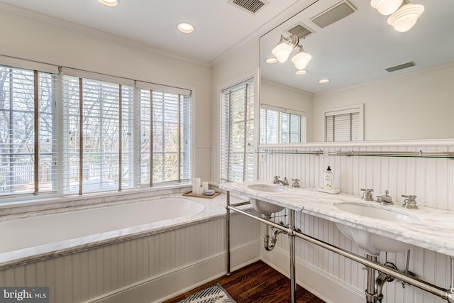 full bath featuring a bath, crown molding, visible vents, and wood finished floors