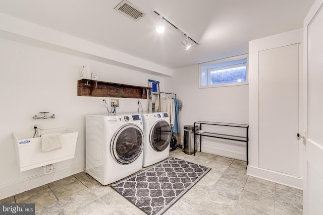 laundry room with laundry area, visible vents, washing machine and clothes dryer, rail lighting, and a sink