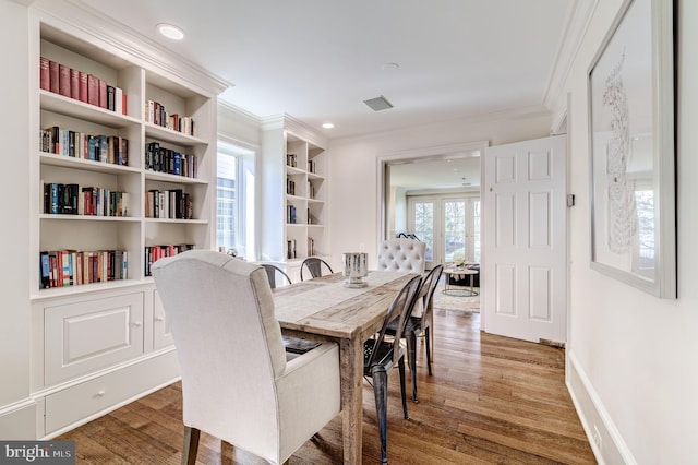 dining room with recessed lighting, crown molding, baseboards, and wood finished floors