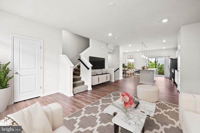 living area with baseboards, stairway, dark wood-style flooring, and recessed lighting