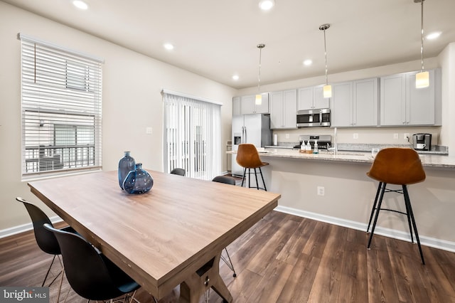 dining room featuring baseboards, dark wood-type flooring, and recessed lighting