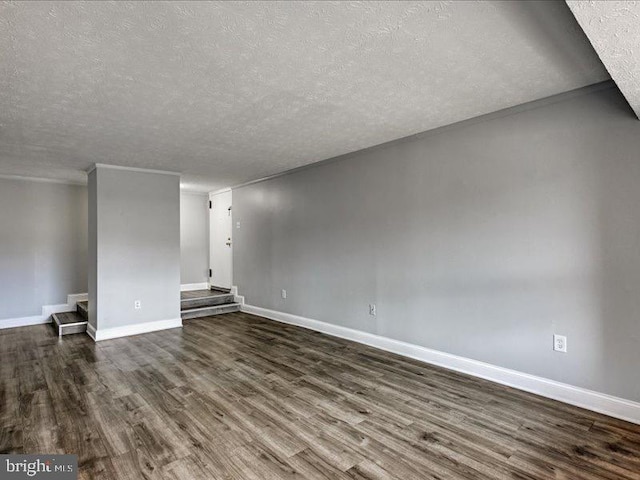 unfurnished living room with stairs, a textured ceiling, baseboards, and dark wood-style flooring