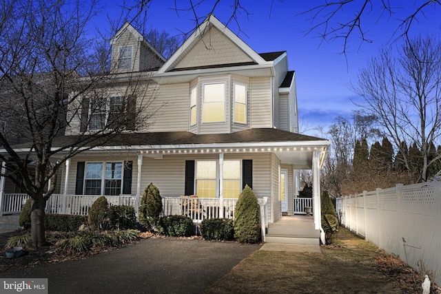 view of front of property featuring fence and a porch