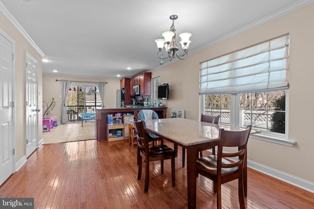 dining room featuring a chandelier, recessed lighting, baseboards, ornamental molding, and light wood-type flooring