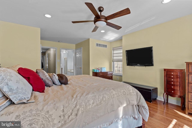 bedroom with recessed lighting, visible vents, connected bathroom, wood finished floors, and baseboards