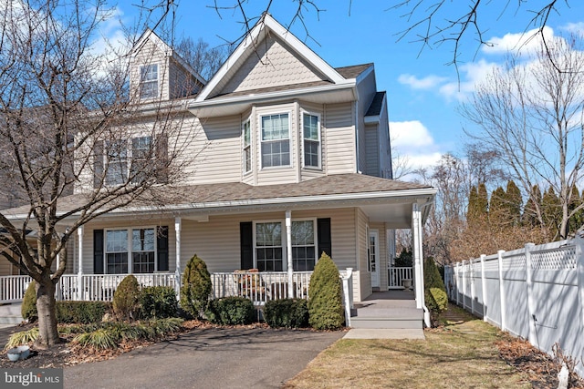 victorian home with covered porch and fence