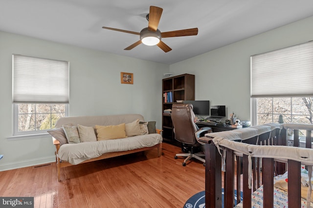 office featuring ceiling fan, wood finished floors, visible vents, and baseboards