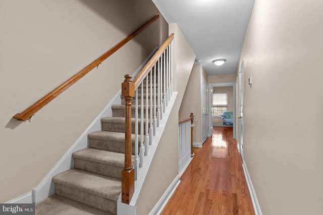 stairs with baseboards and wood finished floors