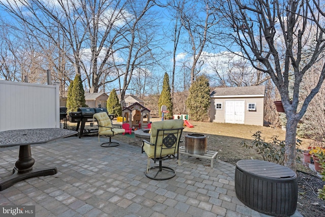 view of patio / terrace featuring a playground, an outdoor structure, and a shed