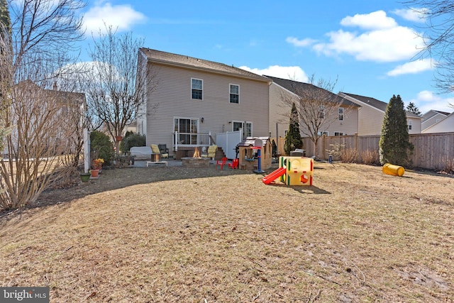 back of house featuring a playground and a fenced backyard