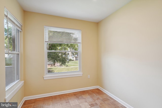 unfurnished room with baseboards