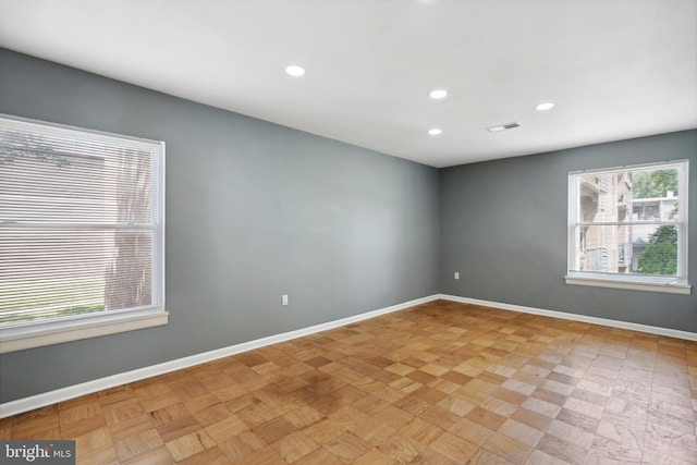 spare room with baseboards, visible vents, and recessed lighting