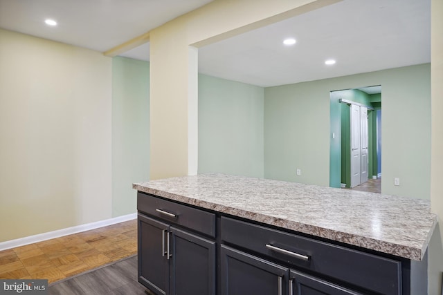 kitchen featuring baseboards, light countertops, and recessed lighting