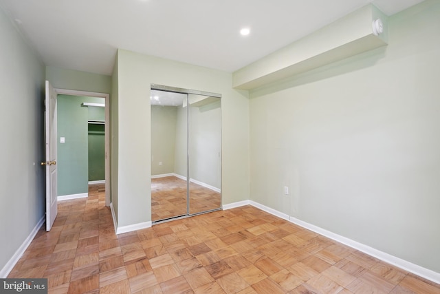 unfurnished bedroom with baseboards, a closet, and recessed lighting