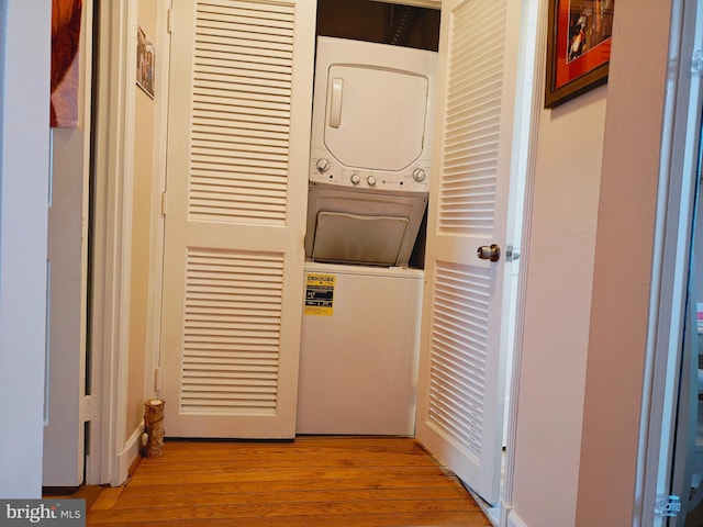 laundry area with light wood-style floors, stacked washer / drying machine, and laundry area