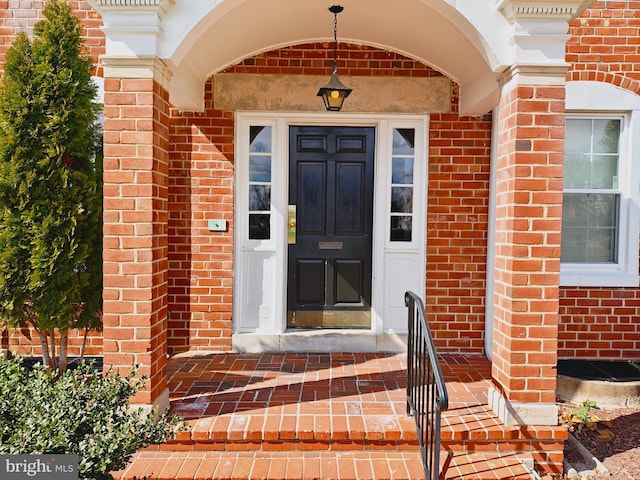 doorway to property featuring brick siding