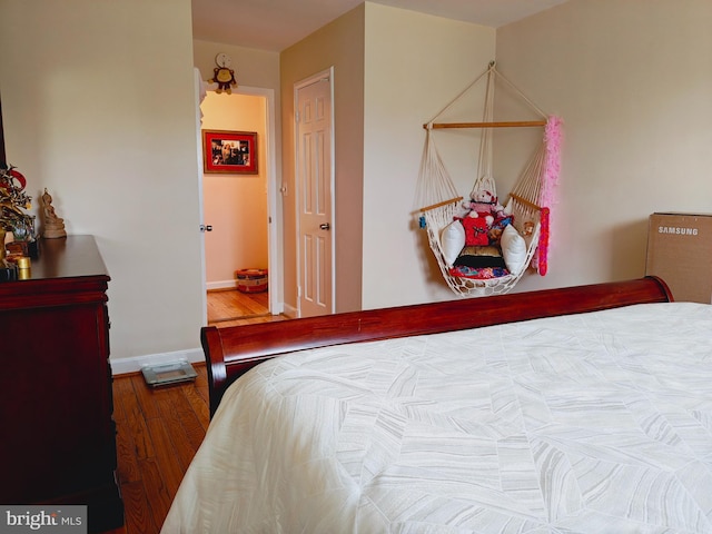 bedroom featuring baseboards and wood finished floors