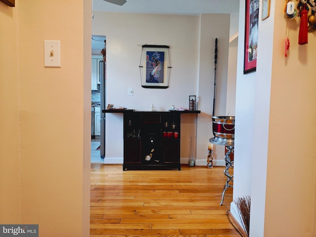 hallway with baseboards and hardwood / wood-style floors