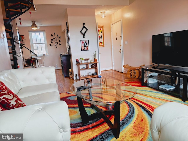 living area with ceiling fan, wood finished floors, and baseboards