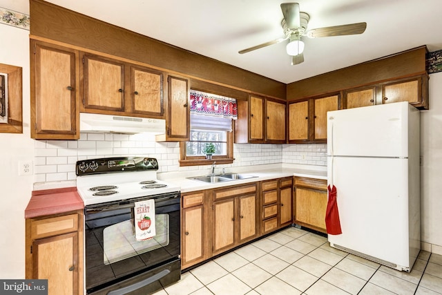 kitchen with black range with electric stovetop, under cabinet range hood, decorative backsplash, freestanding refrigerator, and a sink