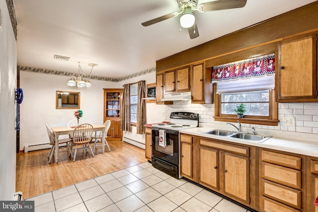 kitchen featuring visible vents, a sink, decorative backsplash, light countertops, and range with electric stovetop