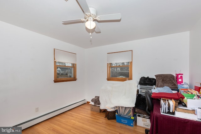 office space featuring wood finished floors, a ceiling fan, and baseboard heating