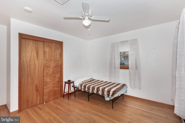 sitting room with baseboards, light wood finished floors, and ceiling fan