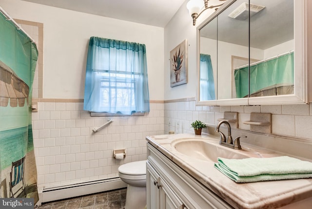 bathroom with vanity, a wainscoted wall, a baseboard heating unit, tile walls, and toilet