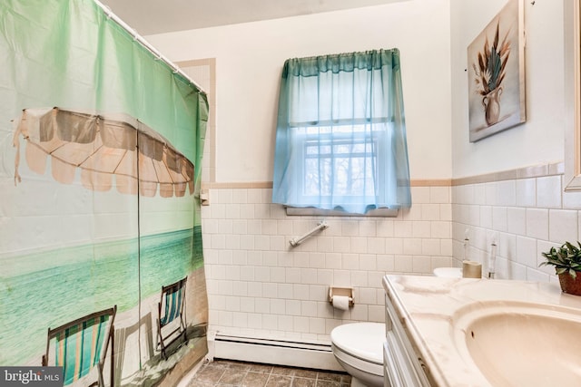 full bathroom featuring a baseboard heating unit, toilet, vanity, a shower with curtain, and tile walls