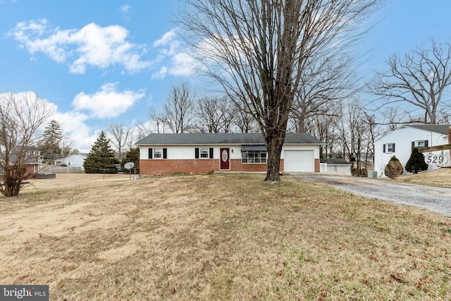 single story home featuring brick siding, a front yard, gravel driveway, and a garage