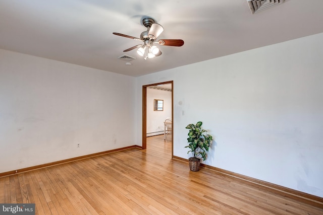 empty room with a baseboard heating unit, a ceiling fan, visible vents, and light wood finished floors