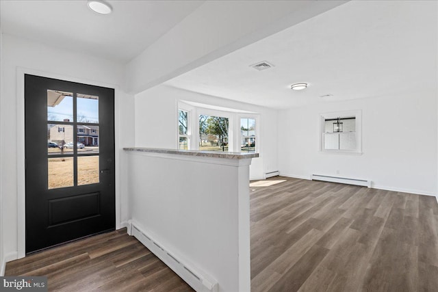 entrance foyer featuring a healthy amount of sunlight, a baseboard radiator, visible vents, and wood finished floors