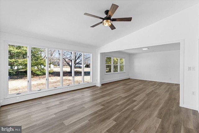 interior space featuring lofted ceiling, a baseboard heating unit, a ceiling fan, wood finished floors, and baseboards