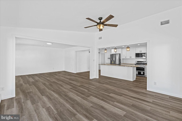 unfurnished living room featuring baseboards, visible vents, a ceiling fan, lofted ceiling, and dark wood-style flooring