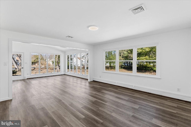 unfurnished living room featuring a healthy amount of sunlight, baseboards, visible vents, and wood finished floors