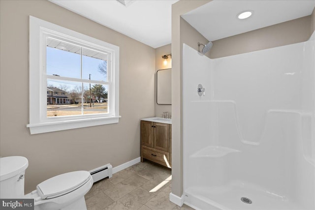 bathroom featuring a shower, baseboard heating, toilet, and baseboards