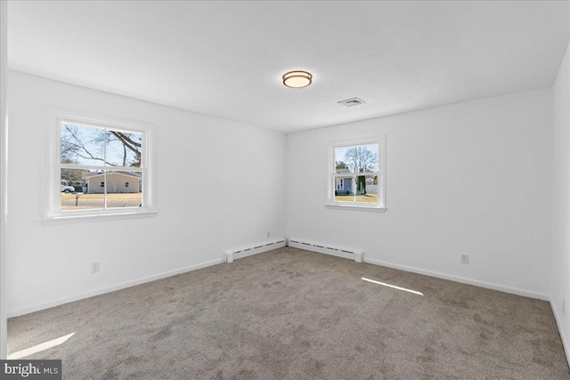 empty room with carpet flooring, visible vents, and baseboards