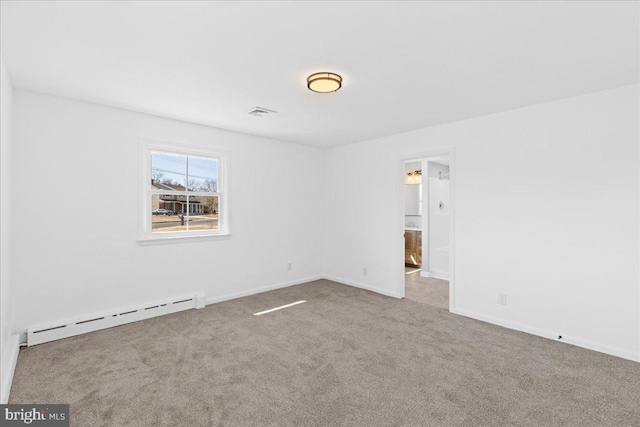 carpeted spare room featuring a baseboard heating unit, visible vents, and baseboards