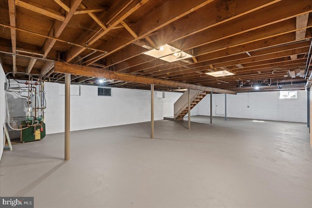 basement featuring a heating unit and stairway